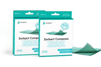 Pakker af Sorbact Compress med en bandage ved siden af.
